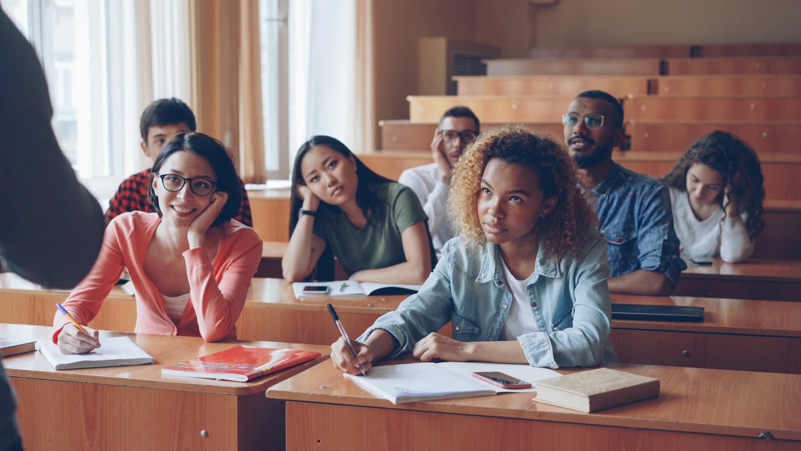 University students listening attentively during a lecture in a tiered lecture hall