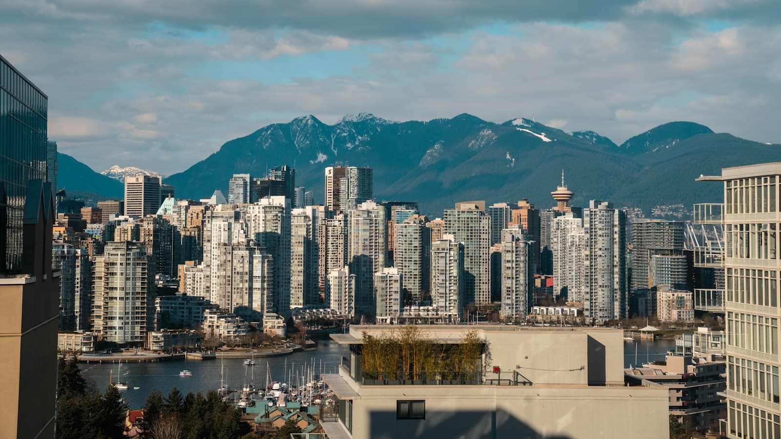 Downtown Vancouver high-rise buildings with forested mountains behind on a clear day