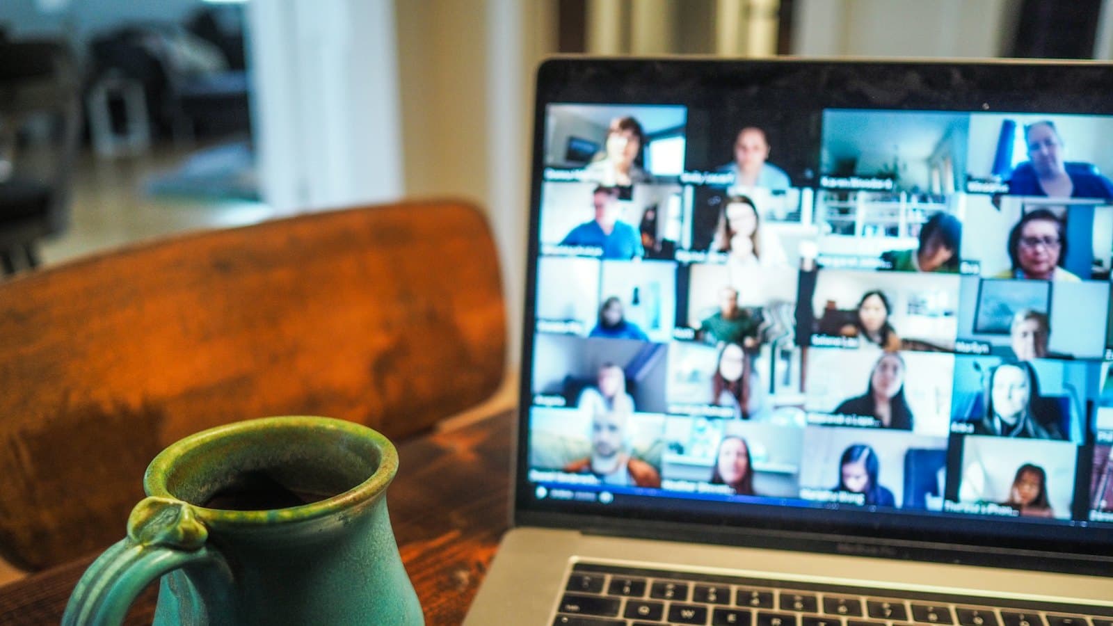 A laptop screen showing a remote team meeting on a video call