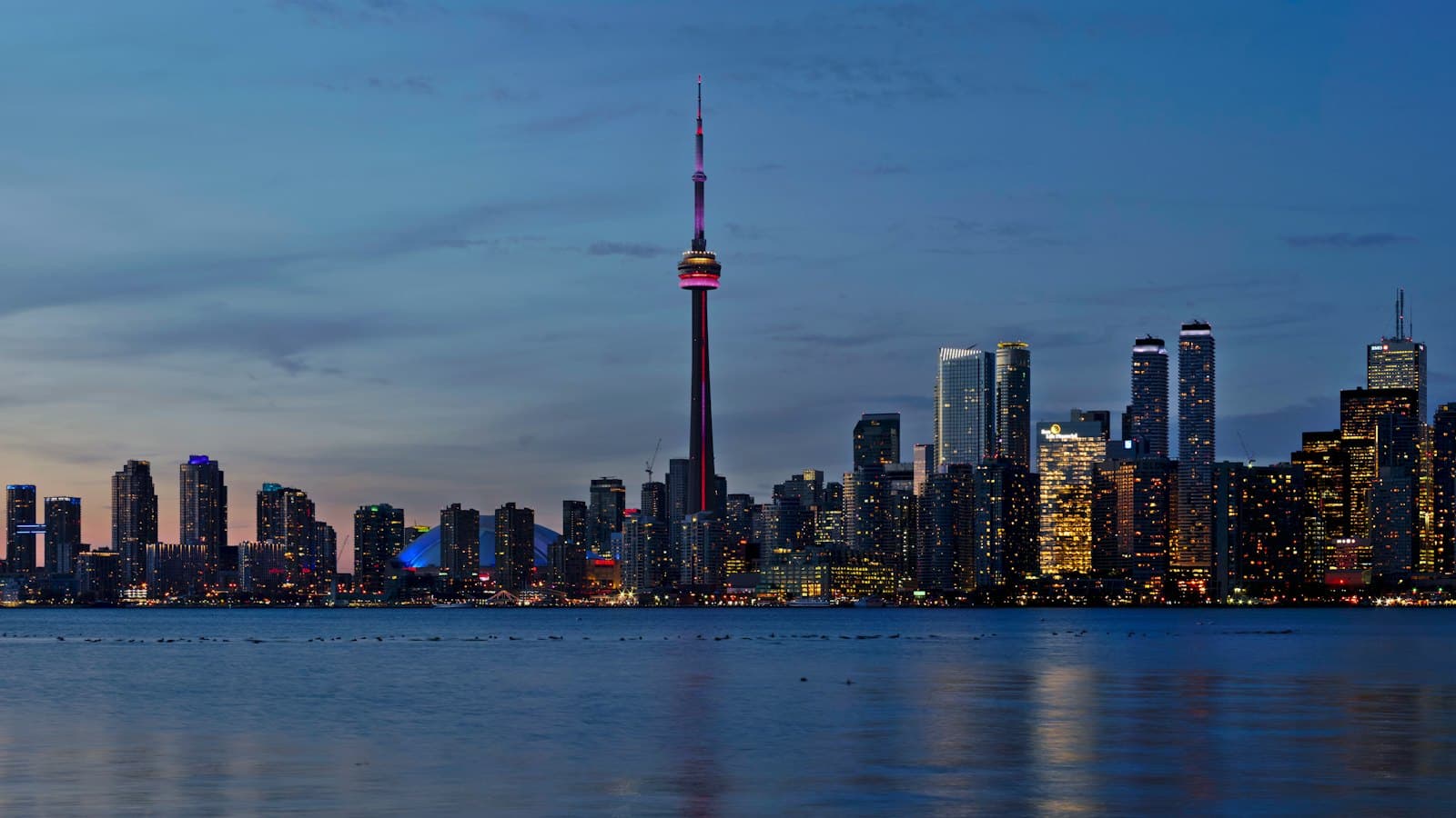 Toronto skyline and CN Tower reflected in Lake Ontario at dusk