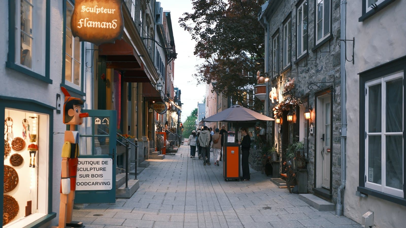 People walking along a historic cobblestone shopping street in Quebec City