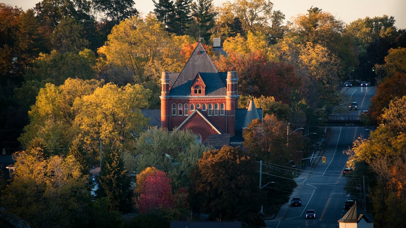 Brick building on a quiet road surrounded by autumn trees in a small town