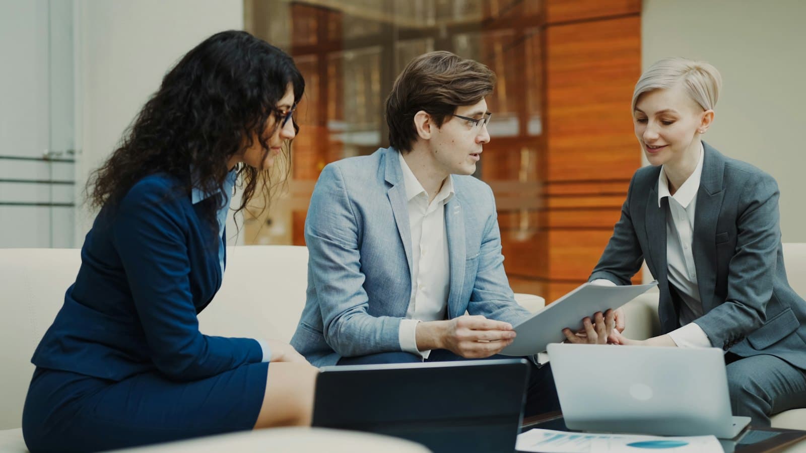 Three professionals discussing documents together at a table