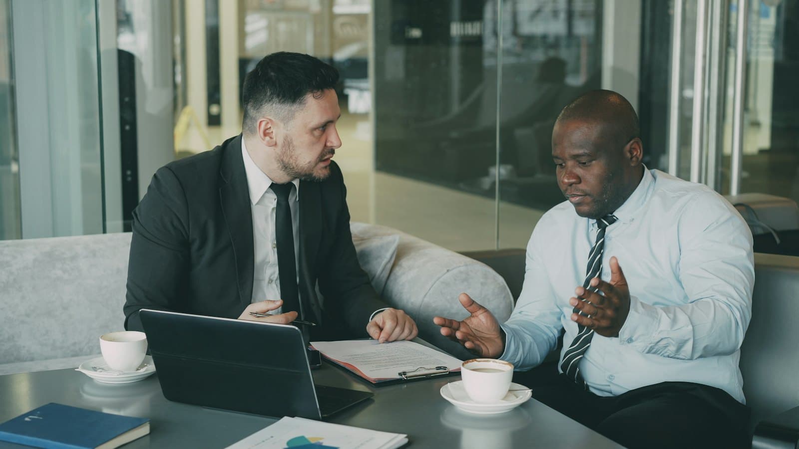 Two colleagues discussing documents together across an office table