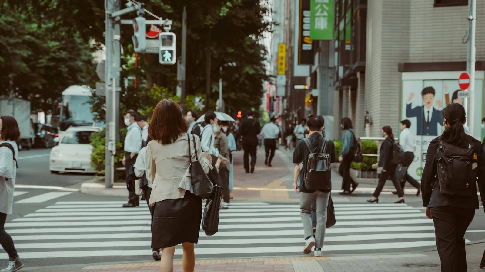 Office workers crossing a busy city street at a zebra crossing