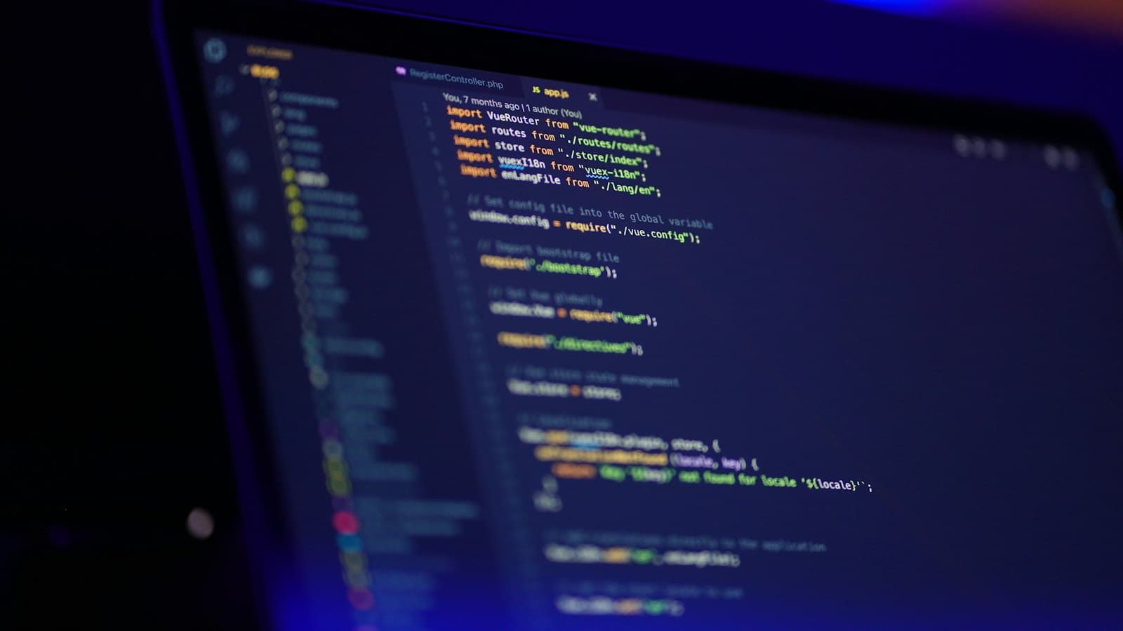 A laptop screen showing colourful lines of code