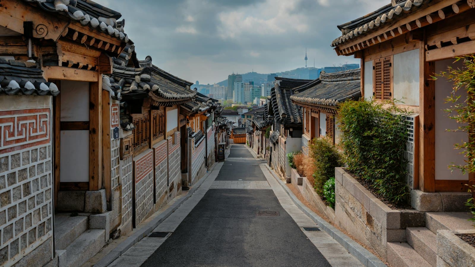 Hanok houses lining a lane in Bukchon, Seoul, with Namsan Tower behind