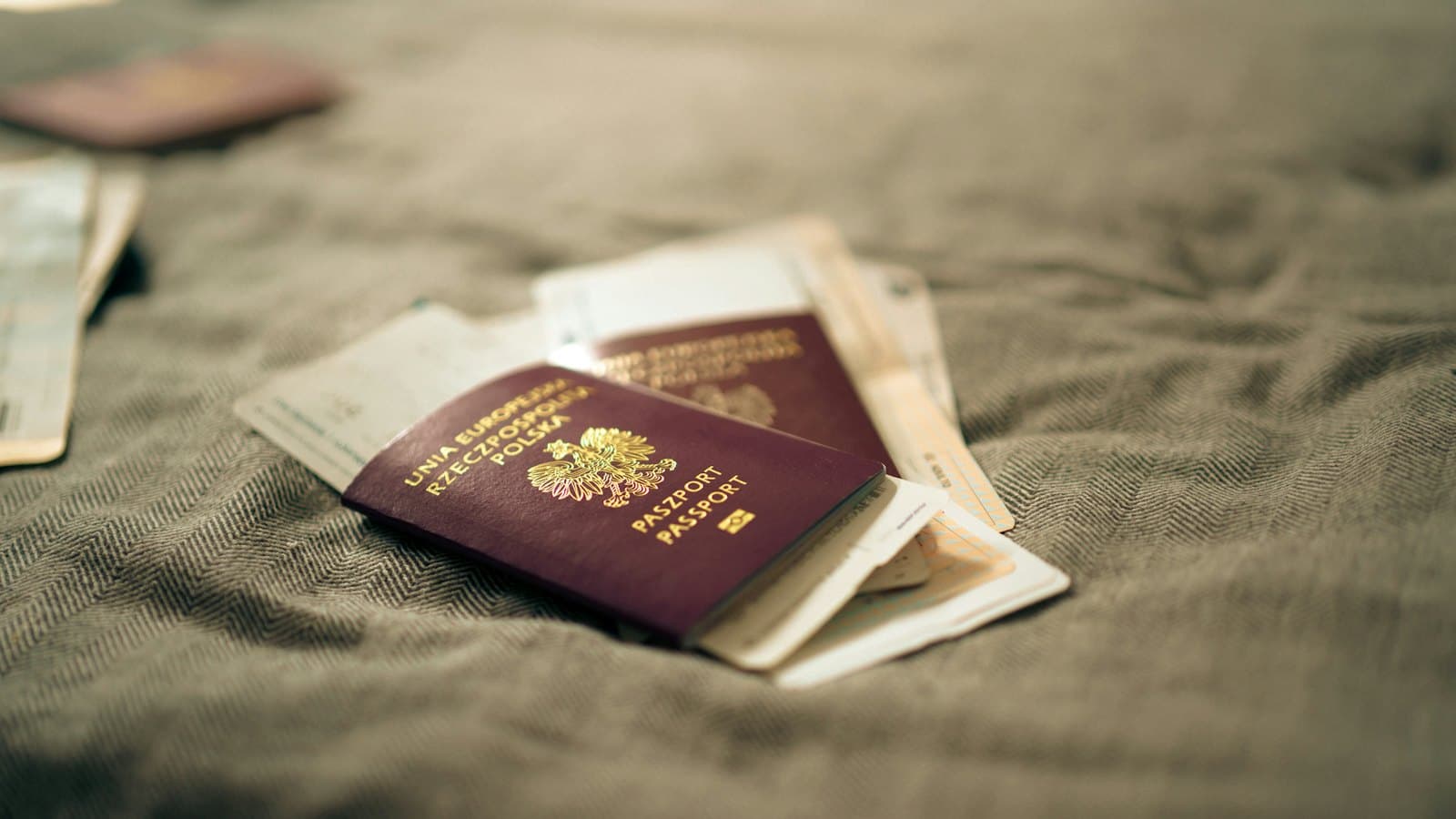 Two passports and boarding passes resting on a soft blanket before a trip