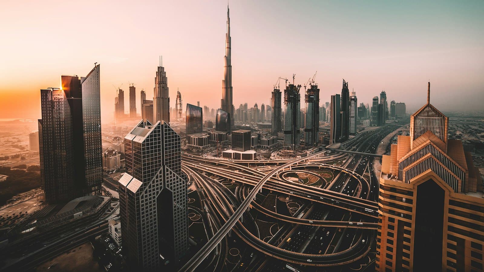 The Burj Khalifa and Dubai skyscrapers rising above a busy highway interchange