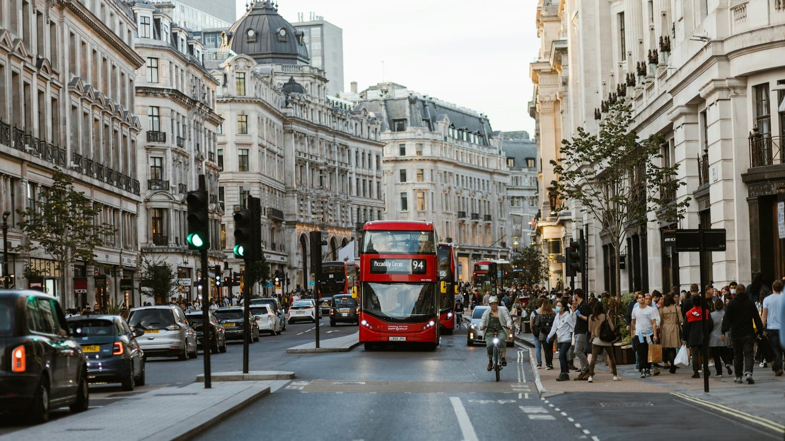 Red double-decker buses and shoppers on Regent Street in central London