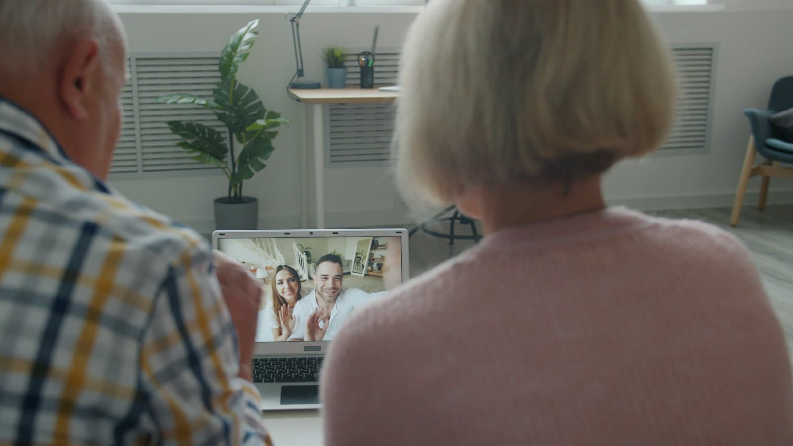 Elderly couple at home on a video call with their family