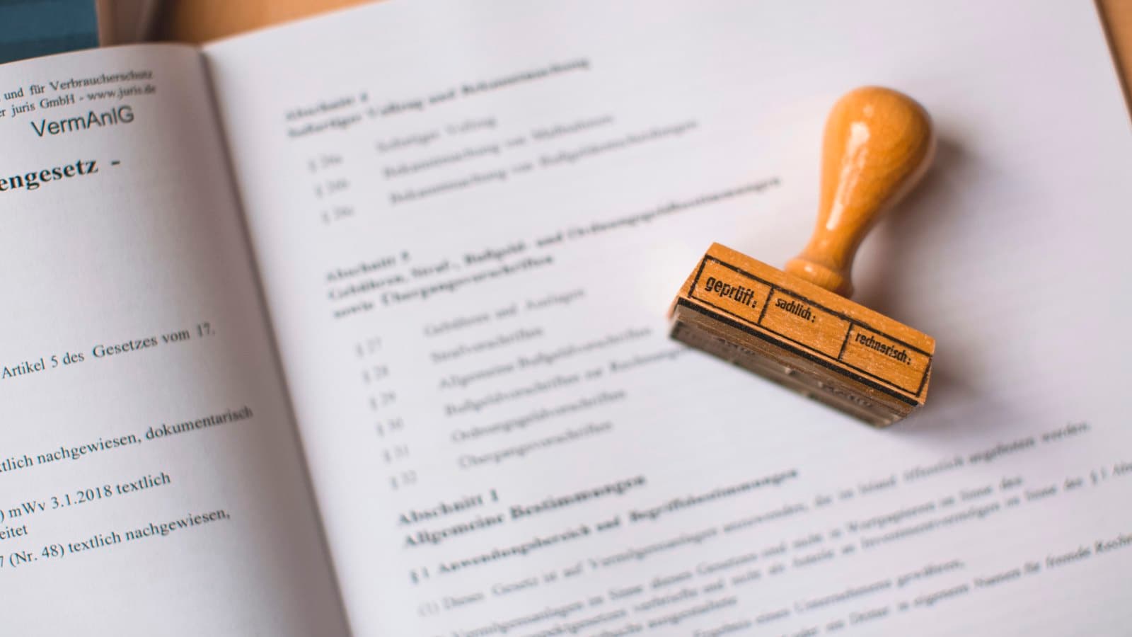A wooden rubber stamp resting on an open legal document on a desk