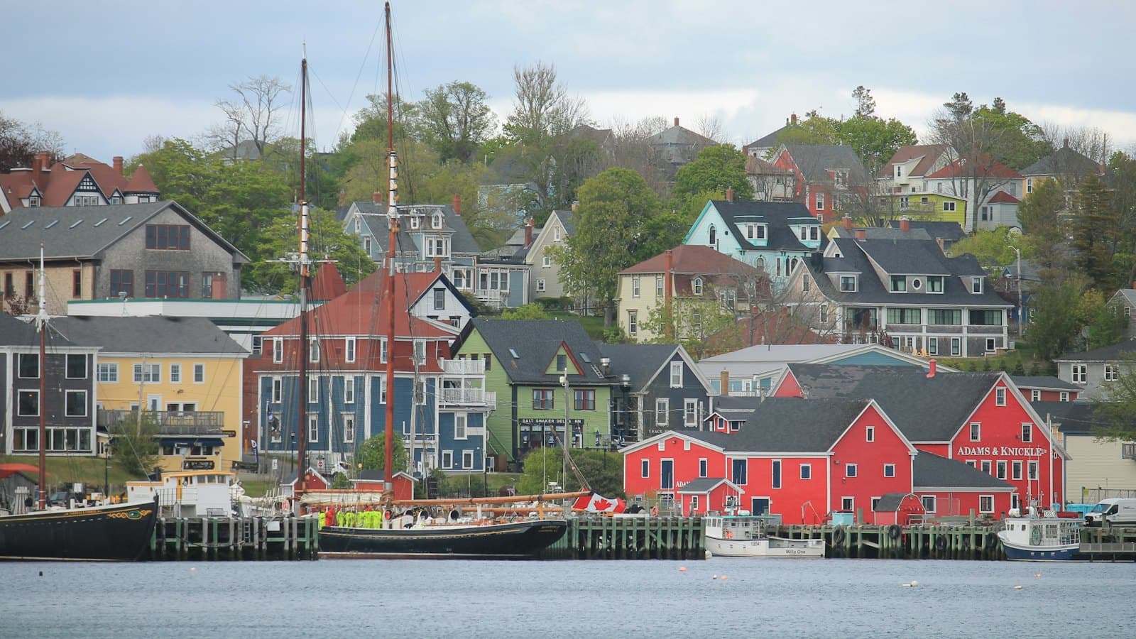 Colourful waterfront buildings and moored sailboats in a small Nova Scotia harbour town