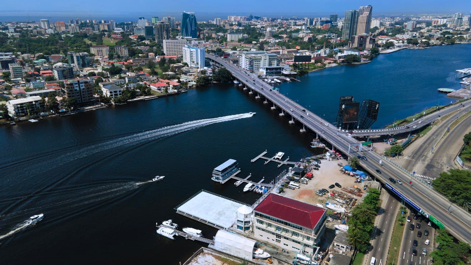 Aerial view of a bridge over the Lagos lagoon with boats and city towers