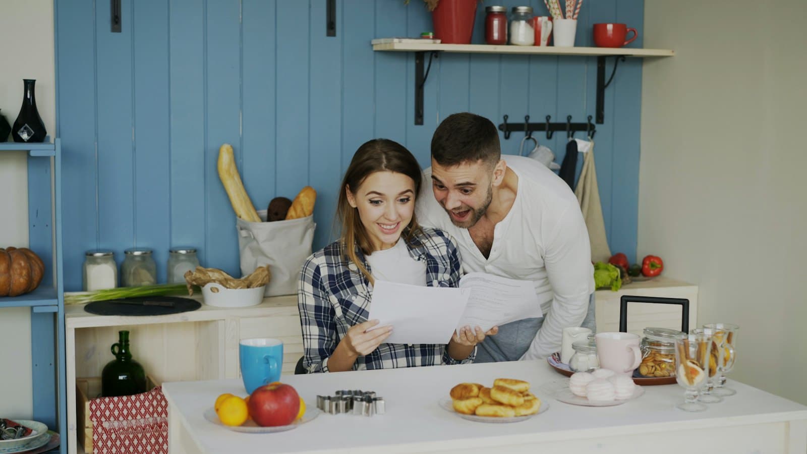 A couple going through papers together at a bright kitchen table