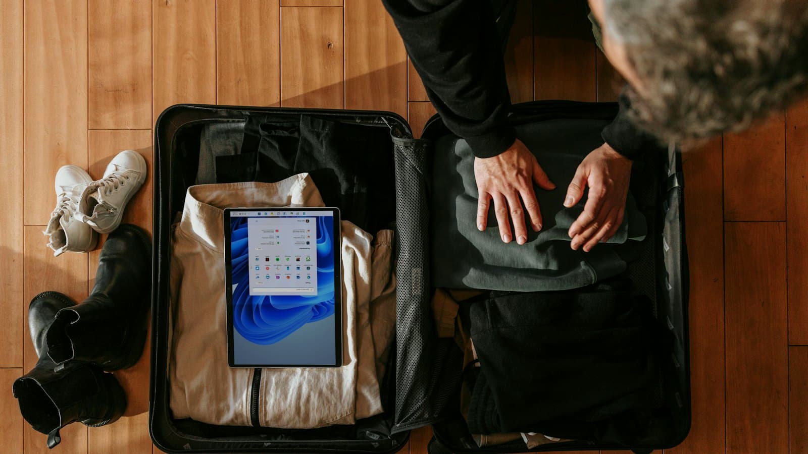 Overhead view of a person packing clothes into a suitcase