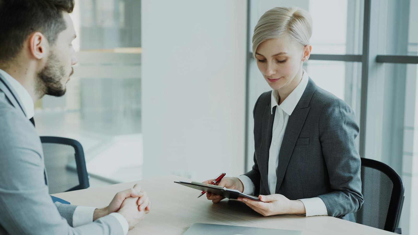 An employer reviewing a document with a job candidate in an office