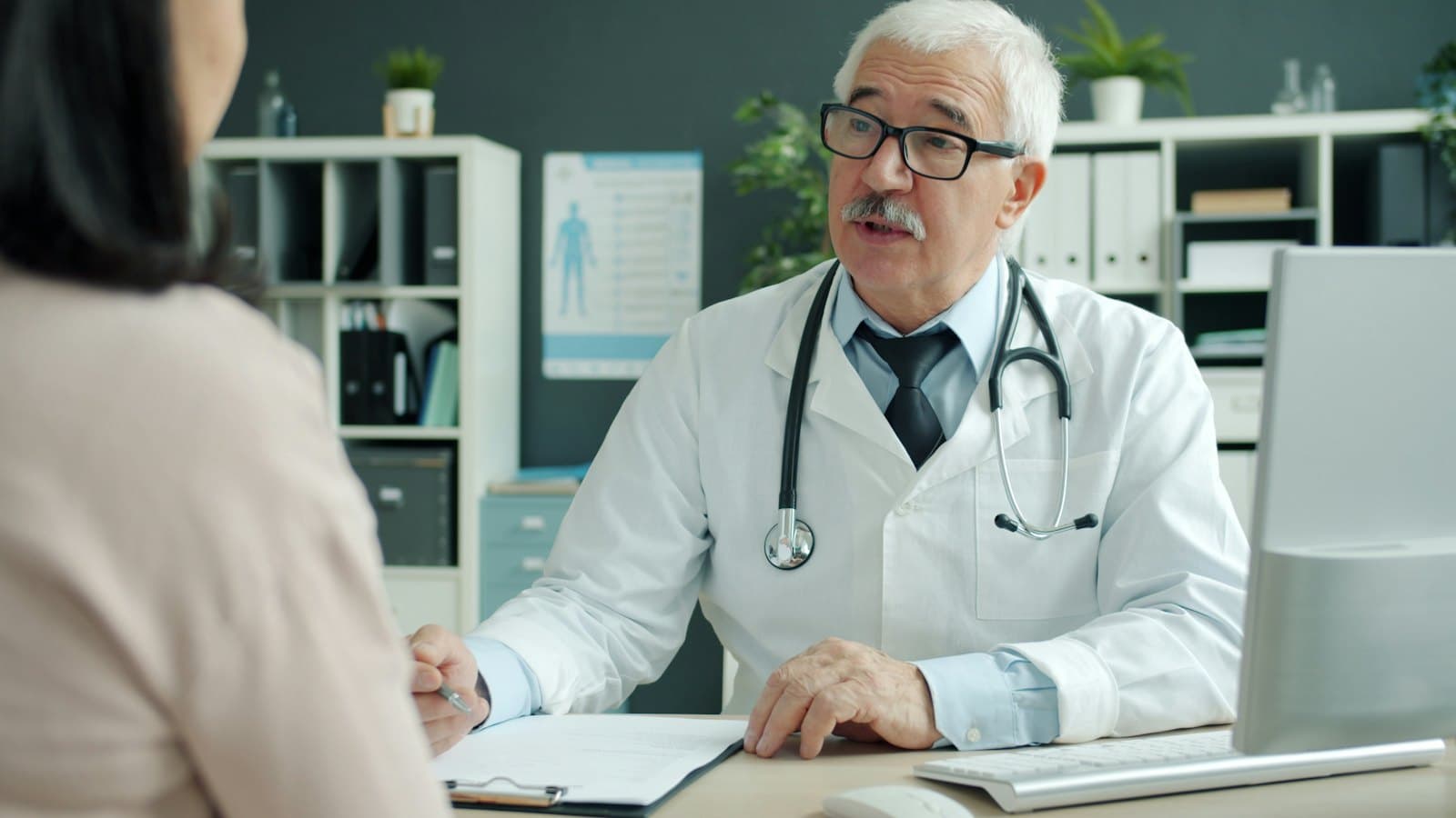 Doctor talking with a patient across a desk in a medical office