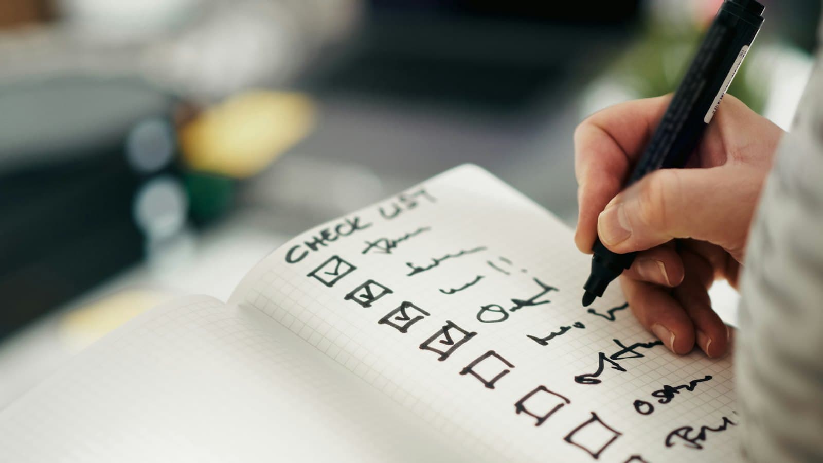 Hand ticking items off a printed checklist with a pen