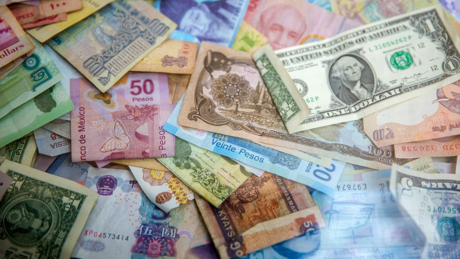 Banknotes from several countries scattered across a flat surface