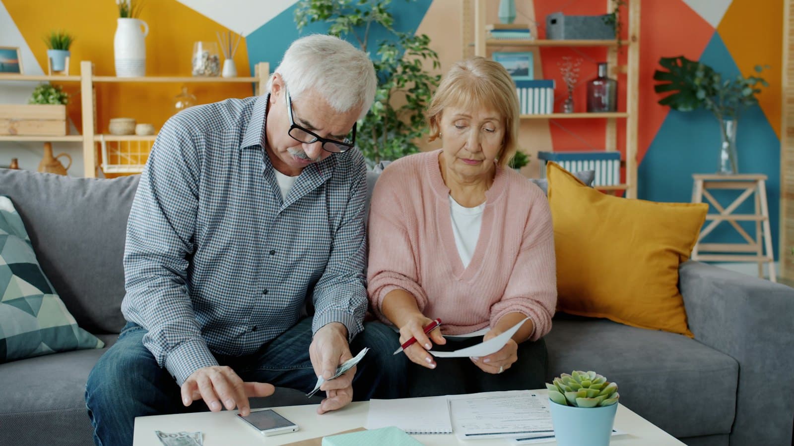 Elderly couple reviewing household documents together at home