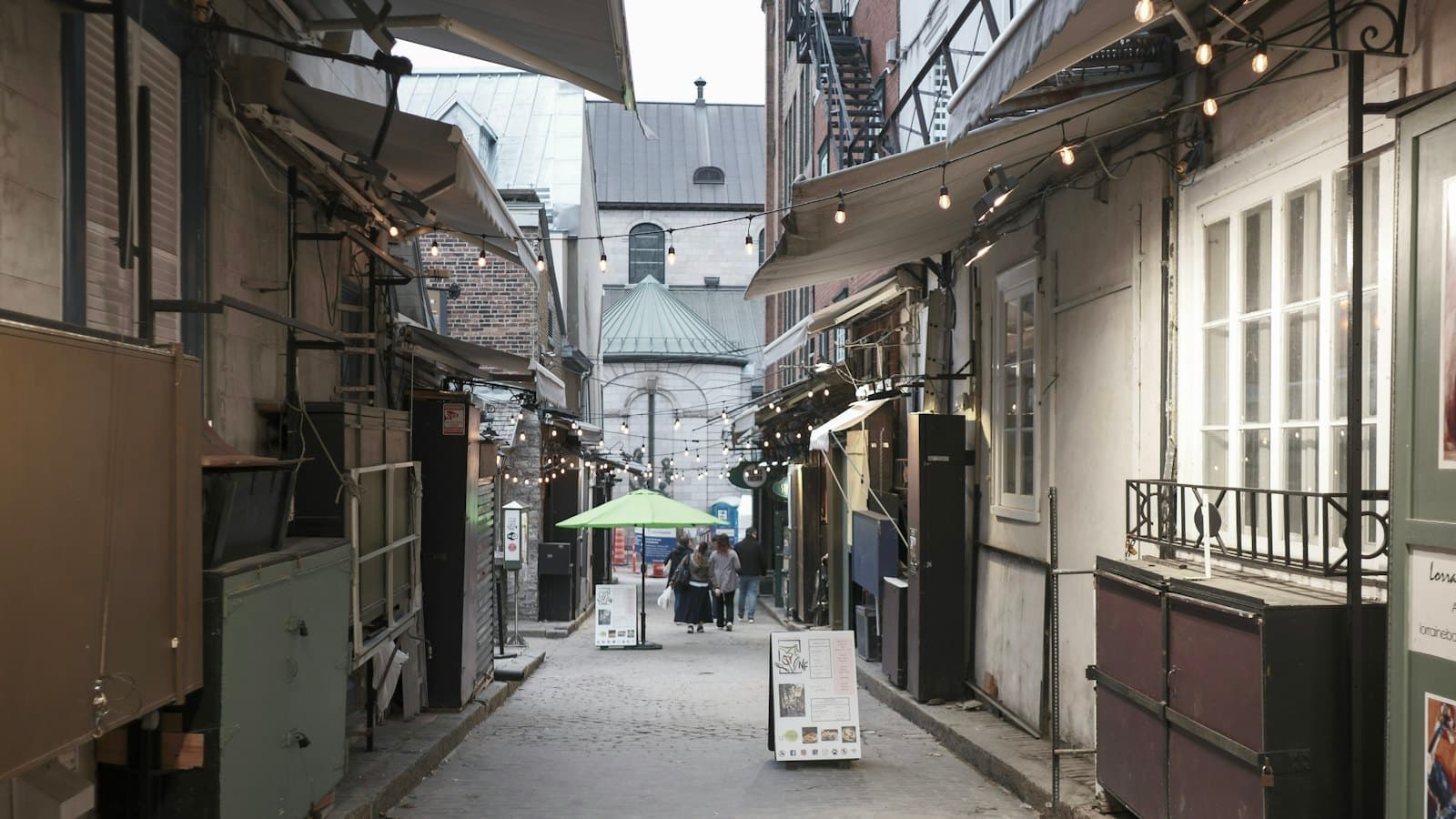 A narrow cobblestone alley in Old Quebec lined with shops and awnings