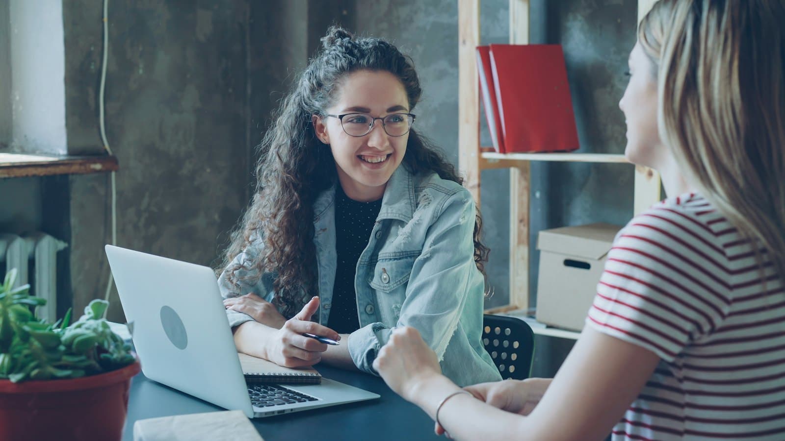 Two women having a friendly discussion at a table